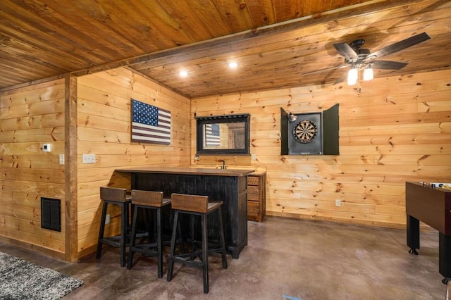 bar with visible vents, wooden ceiling, wood walls, bar area, and concrete flooring