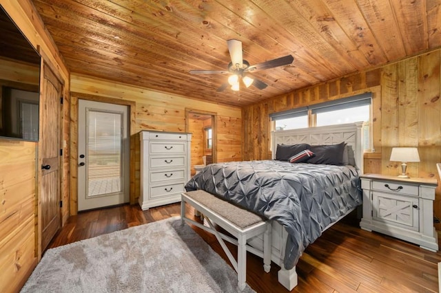 bedroom featuring wooden walls, ensuite bath, ceiling fan, dark wood-type flooring, and wooden ceiling