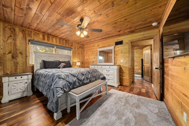 bedroom with wood walls, wooden ceiling, and dark wood-style flooring