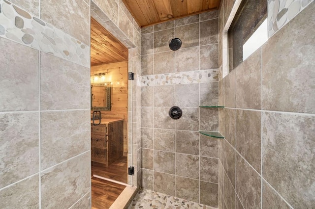 bathroom featuring wooden ceiling, vanity, and a tile shower