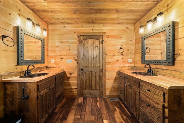 bathroom with wood finished floors, wood ceiling, and a sink