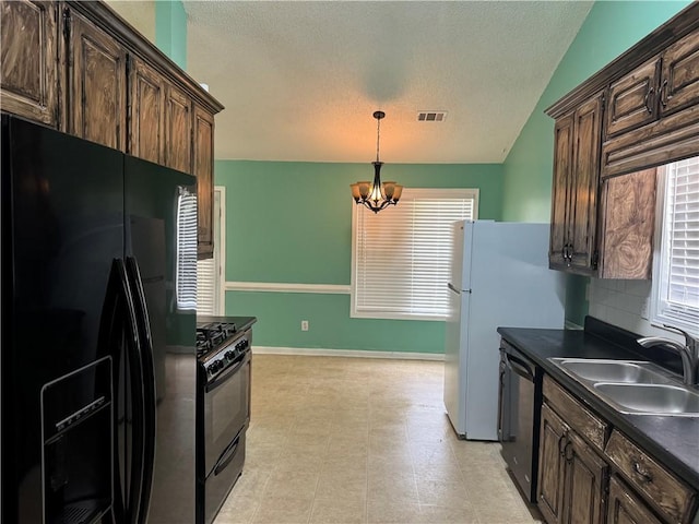 kitchen featuring a sink, a textured ceiling, dark countertops, visible vents, and black appliances