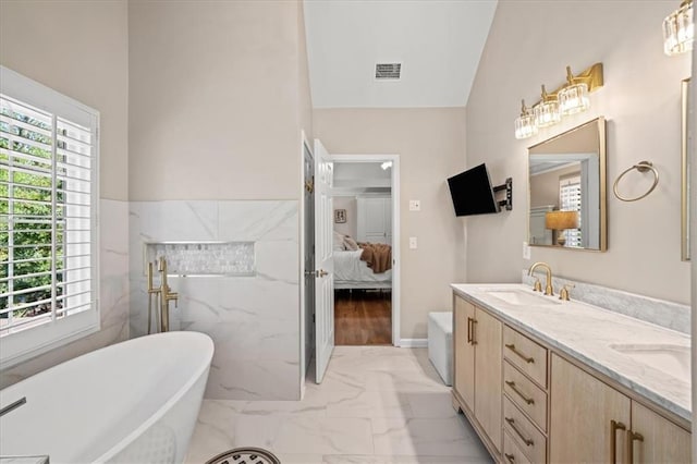 230 Bristol Stone Ct, Johns Creek, GA 30005 - ensuite bathroom featuring marble finish flooring, a soaking tub, double vanity, a wainscoted wall, and vaulted ceiling