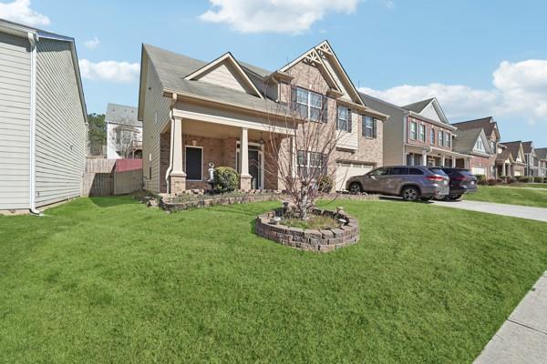 view of front facade with driveway, a residential view, and a front lawn