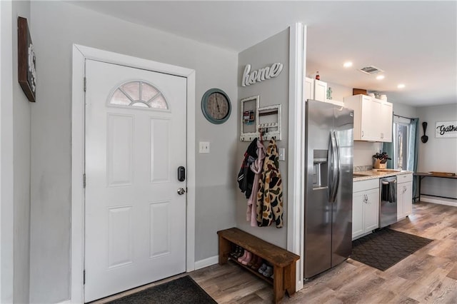 foyer with light wood-type flooring, visible vents, baseboards, and recessed lighting