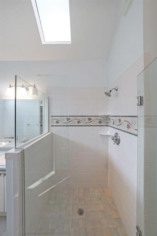 full bathroom with tiled shower and vanity