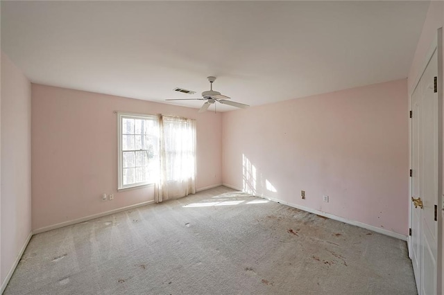 unfurnished room with light colored carpet, visible vents, ceiling fan, and baseboards