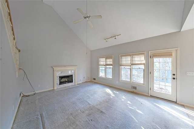 unfurnished living room featuring high vaulted ceiling, a premium fireplace, visible vents, and a healthy amount of sunlight