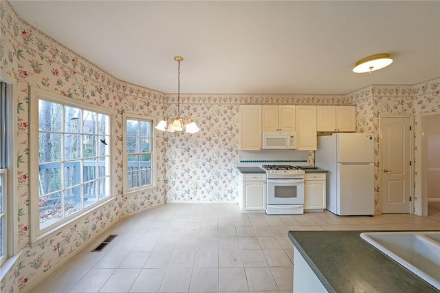 kitchen featuring white appliances, a sink, visible vents, dark countertops, and wallpapered walls