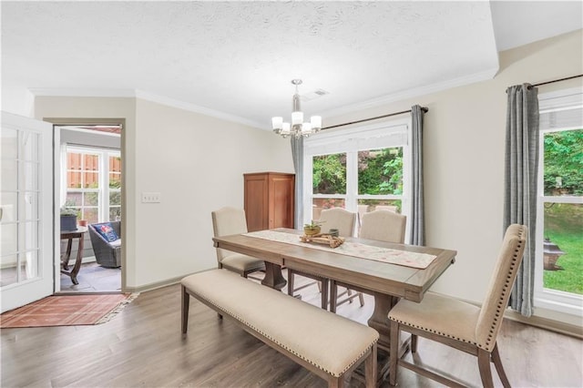 3320 Goldmist Dr, Buford, GA 30519 - dining area featuring a chandelier, light wood-style flooring, healthy amount of natural light, ornamental molding, and a textured ceiling