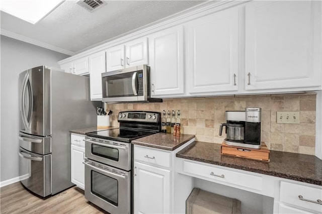 3320 Goldmist Dr, Buford, GA 30519 - kitchen featuring stainless steel appliances, white cabinetry, tasteful backsplash, crown molding, and light wood-style flooring