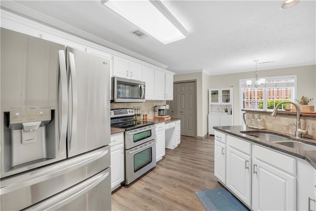 3320 Goldmist Dr, Buford, GA 30519 - kitchen featuring appliances with stainless steel finishes, a sink, backsplash, white cabinetry, and crown molding