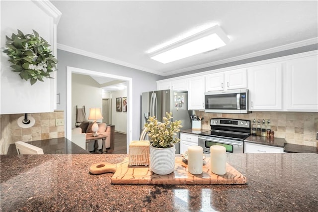 3320 Goldmist Dr, Buford, GA 30519 - kitchen with appliances with stainless steel finishes, backsplash, white cabinetry, ornamental molding, and dark stone counters