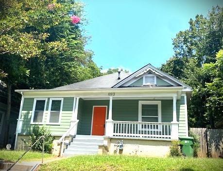 view of front of home with a front yard and covered porch