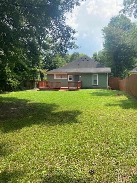 back of property featuring a yard and a deck