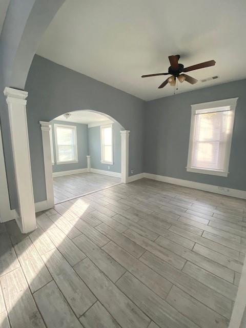 unfurnished room with ceiling fan and ornate columns