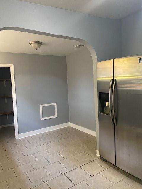 kitchen featuring light tile patterned floors and stainless steel refrigerator with ice dispenser