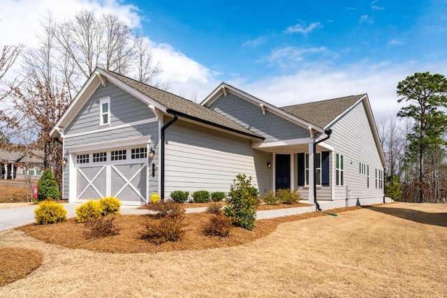 ranch-style home featuring driveway, a shingled roof, and a garage