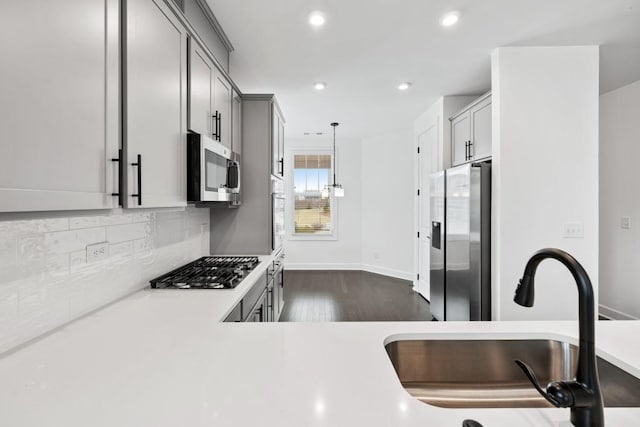 kitchen featuring dark wood-style floors, stainless steel appliances, recessed lighting, light countertops, and backsplash