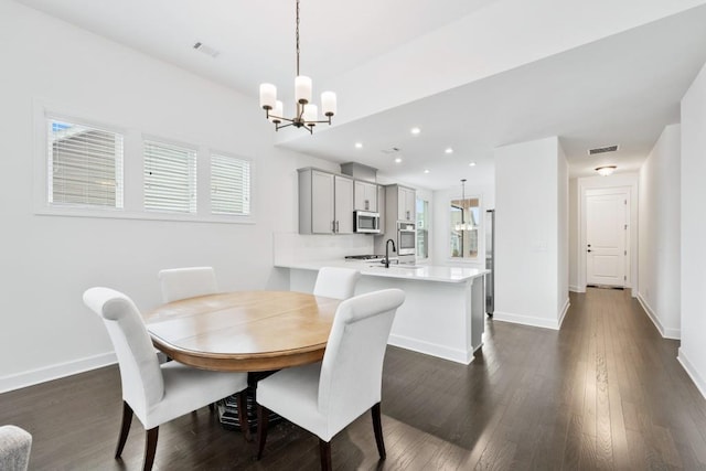 dining area featuring a chandelier, recessed lighting, dark wood-style flooring, visible vents, and baseboards