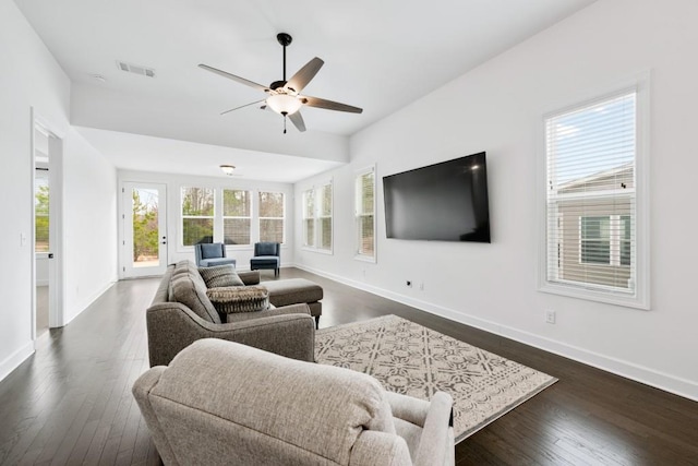 living room with dark wood finished floors, visible vents, and baseboards