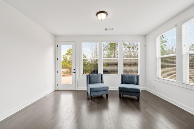 sitting room with baseboards, dark wood finished floors, visible vents, and a healthy amount of sunlight