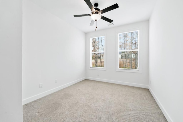 unfurnished room featuring light carpet, visible vents, baseboards, and ceiling fan