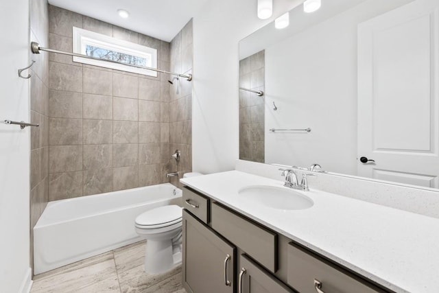 bathroom featuring tub / shower combination, vanity, and toilet