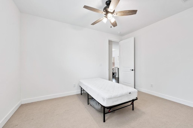 bedroom with light colored carpet, ceiling fan, and baseboards