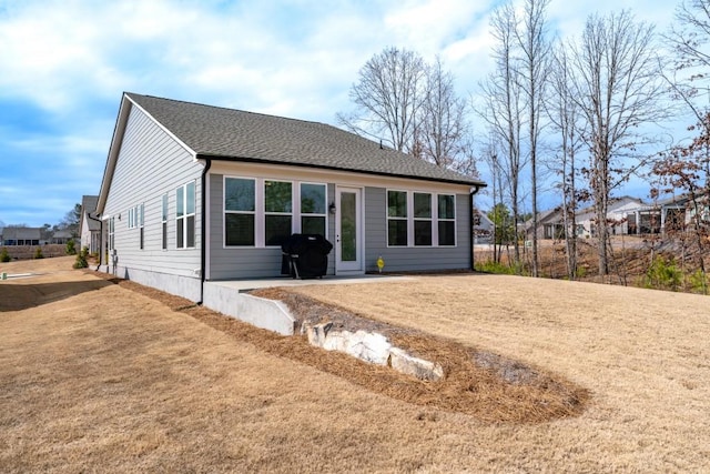 view of front of house featuring roof with shingles and a front yard