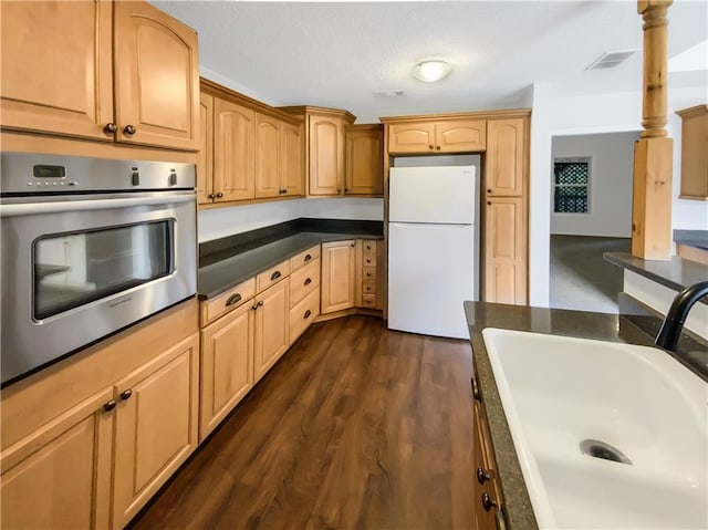131 Morningside Dr, Jackson, GA 30233 - kitchen with freestanding refrigerator, stainless steel oven, dark countertops, and dark wood-type flooring
