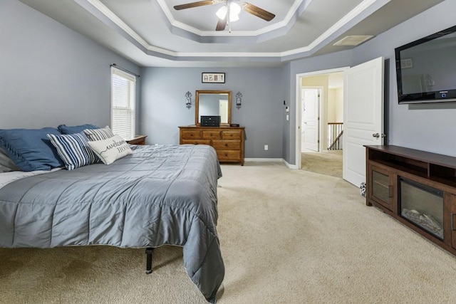 bedroom with baseboards, a raised ceiling, a ceiling fan, light colored carpet, and ornamental molding