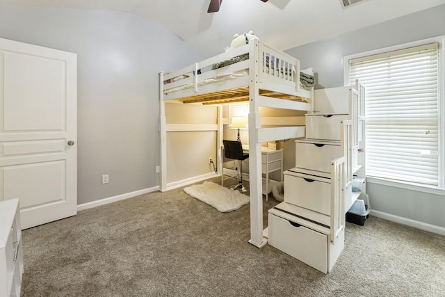 carpeted bedroom with visible vents, vaulted ceiling, baseboards, and ceiling fan