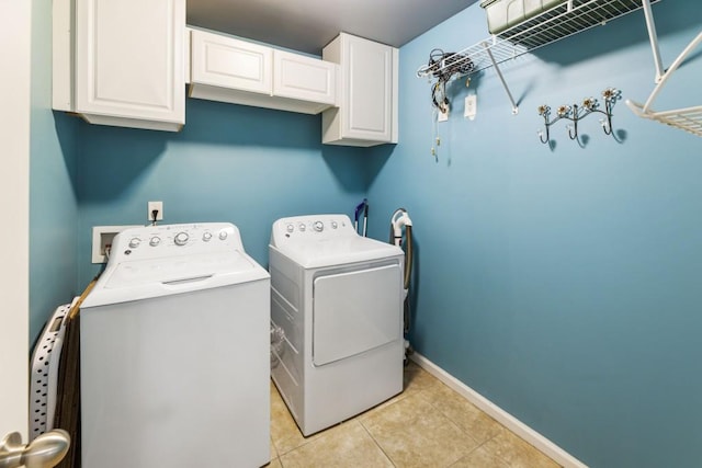 laundry room with cabinet space, light tile patterned floors, baseboards, and separate washer and dryer