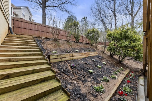 view of yard with a fenced backyard and stairway