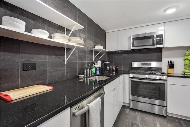 kitchen with open shelves, decorative backsplash, white cabinetry, a sink, and stainless steel appliances