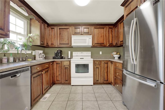192 Aubrey Ave NE, Calhoun, GA 30701 - kitchen featuring light tile patterned floors, a sink, brown cabinets, and appliances with stainless steel finishes
