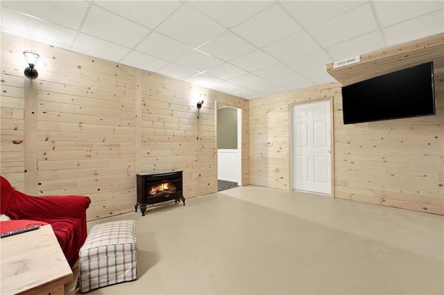192 Aubrey Ave NE, Calhoun, GA 30701 - unfurnished room with finished concrete flooring, a warm lit fireplace, visible vents, and a paneled ceiling