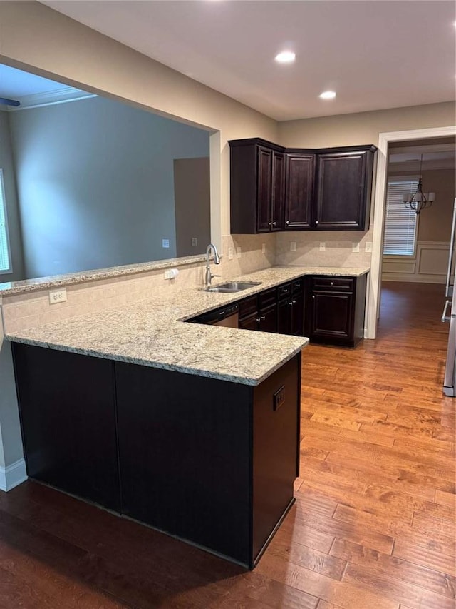 3622 Foxtrot Trl NW, Kennesaw, GA 30144 - kitchen featuring a sink, light stone countertops, a peninsula, light wood finished floors, and dark brown cabinets