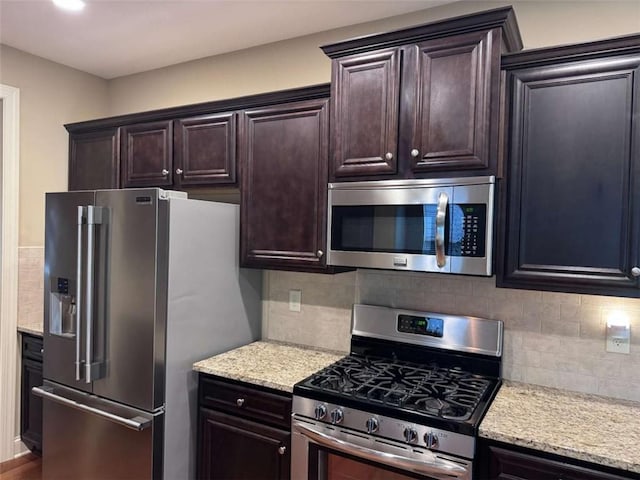3622 Foxtrot Trl NW, Kennesaw, GA 30144 - kitchen featuring appliances with stainless steel finishes, tasteful backsplash, dark brown cabinets, light stone counters, and recessed lighting