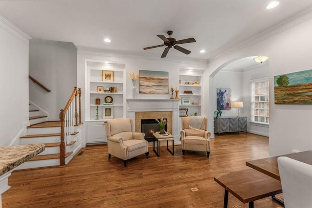 1227 Parkside Village Dr NW, Marietta, GA 30060 - living area with ornamental molding, a ceiling fan, wood finished floors, a tiled fireplace, and stairway