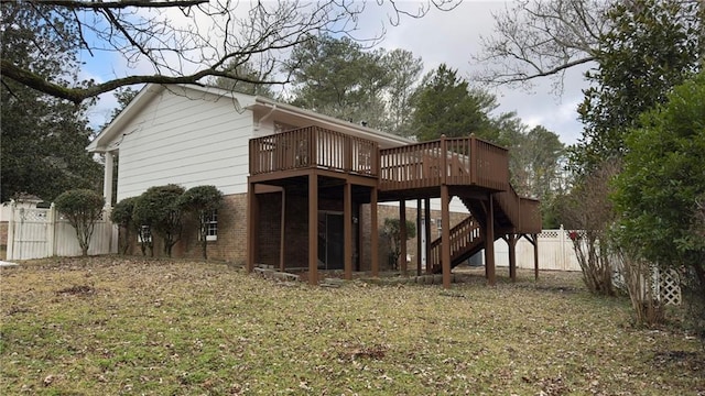 rear view of house featuring a deck and a yard