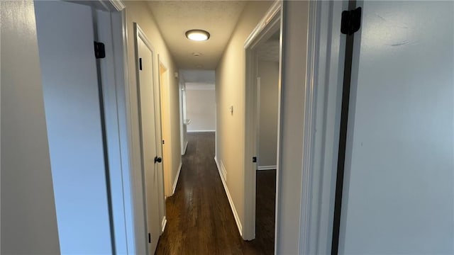 hallway with dark hardwood / wood-style flooring