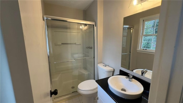 bathroom featuring toilet, tile patterned floors, walk in shower, and vanity