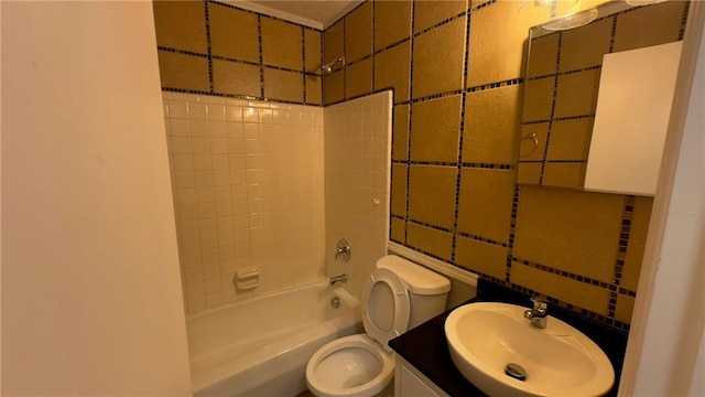 full bathroom with toilet, shower / washtub combination, vanity, and tile walls