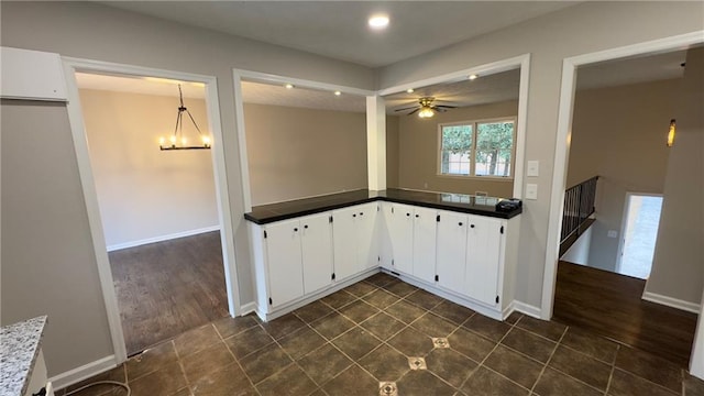 kitchen featuring white cabinets, decorative light fixtures, and ceiling fan with notable chandelier