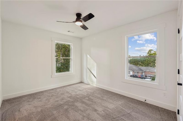 carpeted spare room with ceiling fan and a wealth of natural light