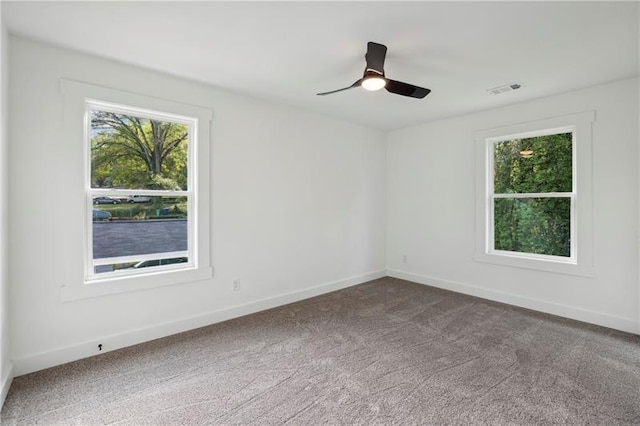 carpeted spare room with ceiling fan