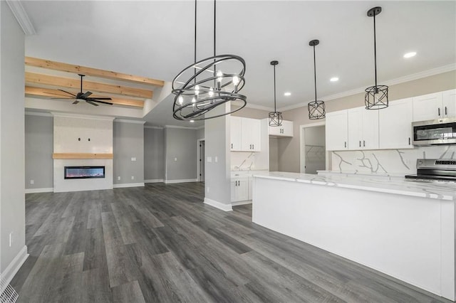 kitchen with decorative backsplash, light stone countertops, stainless steel appliances, ceiling fan, and white cabinets