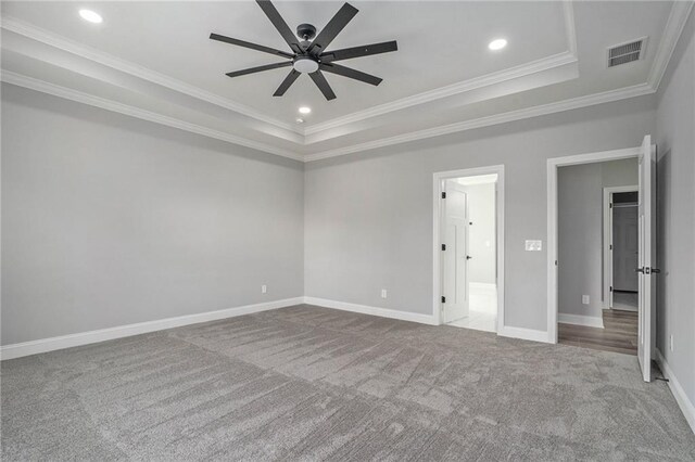 unfurnished room with ceiling fan, a raised ceiling, carpet floors, and crown molding